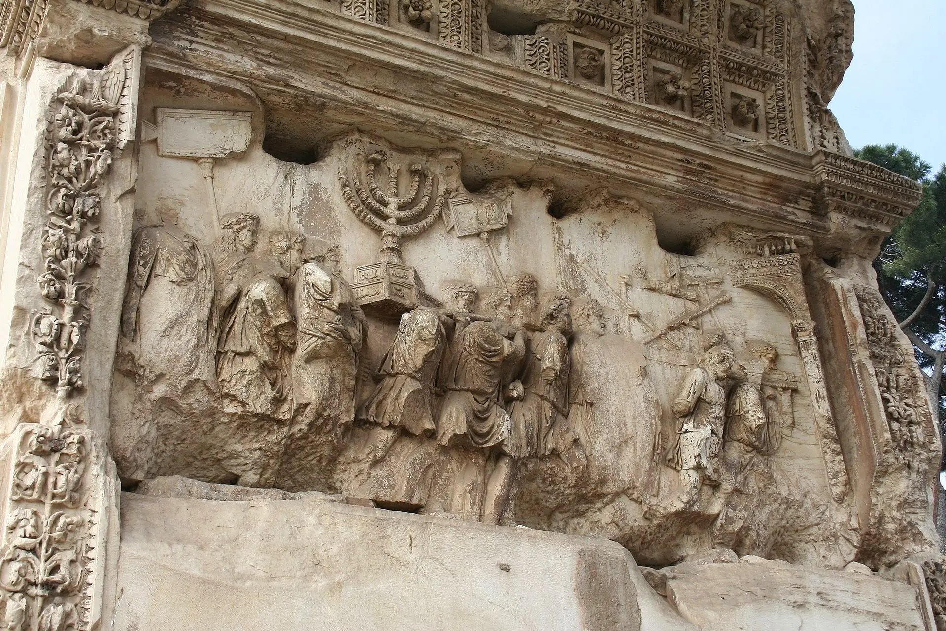 fig5 : Candélabre à sept branches gravée sur l’Arc de Titus peu après sa mort en 81 après J.-C., pour commémorer sa victoire en Judée | Relief du passage central, pilier sud de l’Arc de Titus, Rome antique. (Crédit : ©Cassius Ahenobarbus | https://commons.wikimedia.org/wiki/File:Arc_titus_relief_sud.jpg)